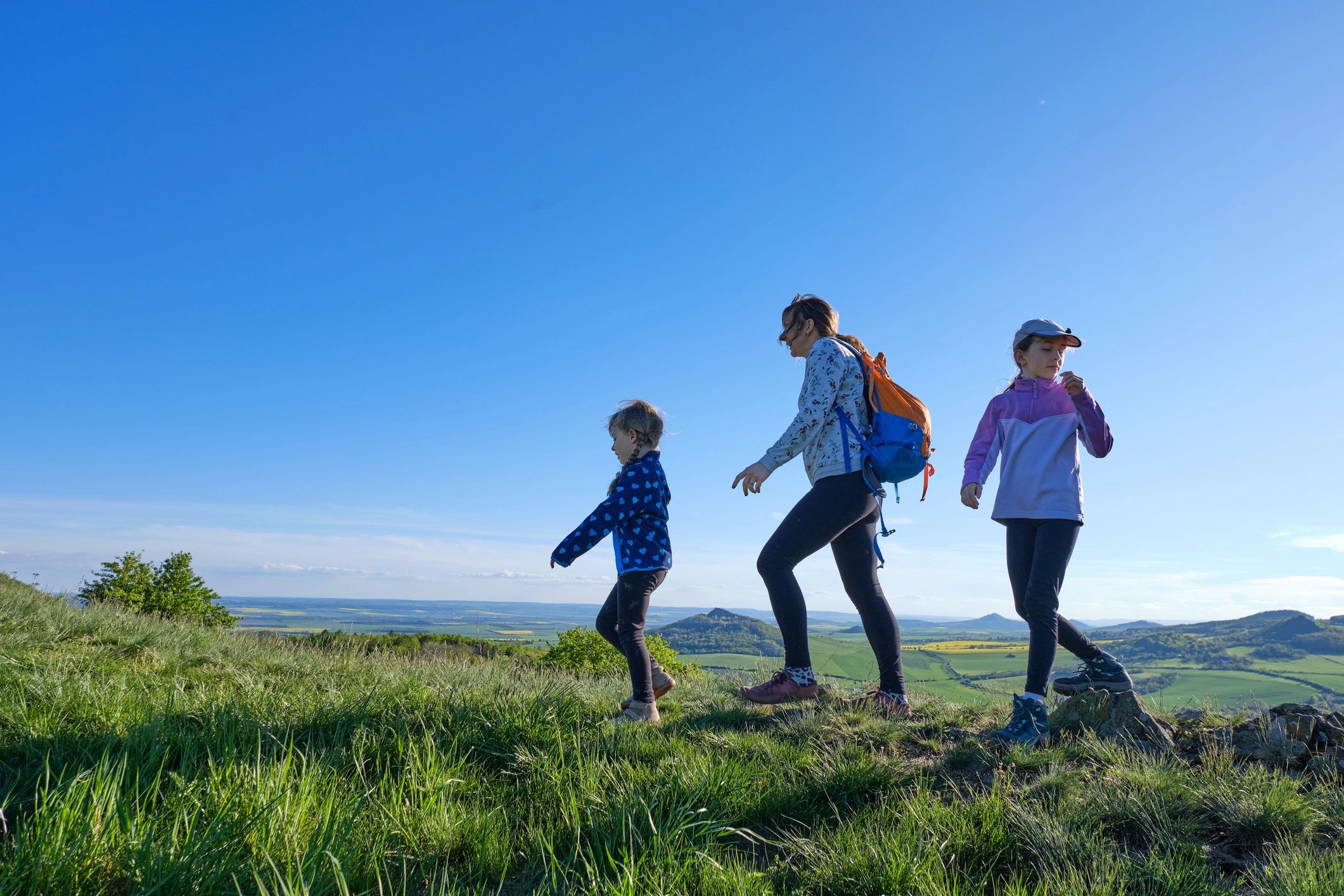 Family hiking on a sunny countryside ridge